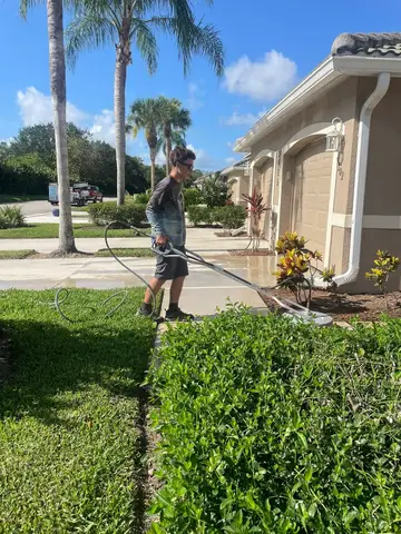 Cleaning sidewalk and driveway area with pressure washer in Cape Coral